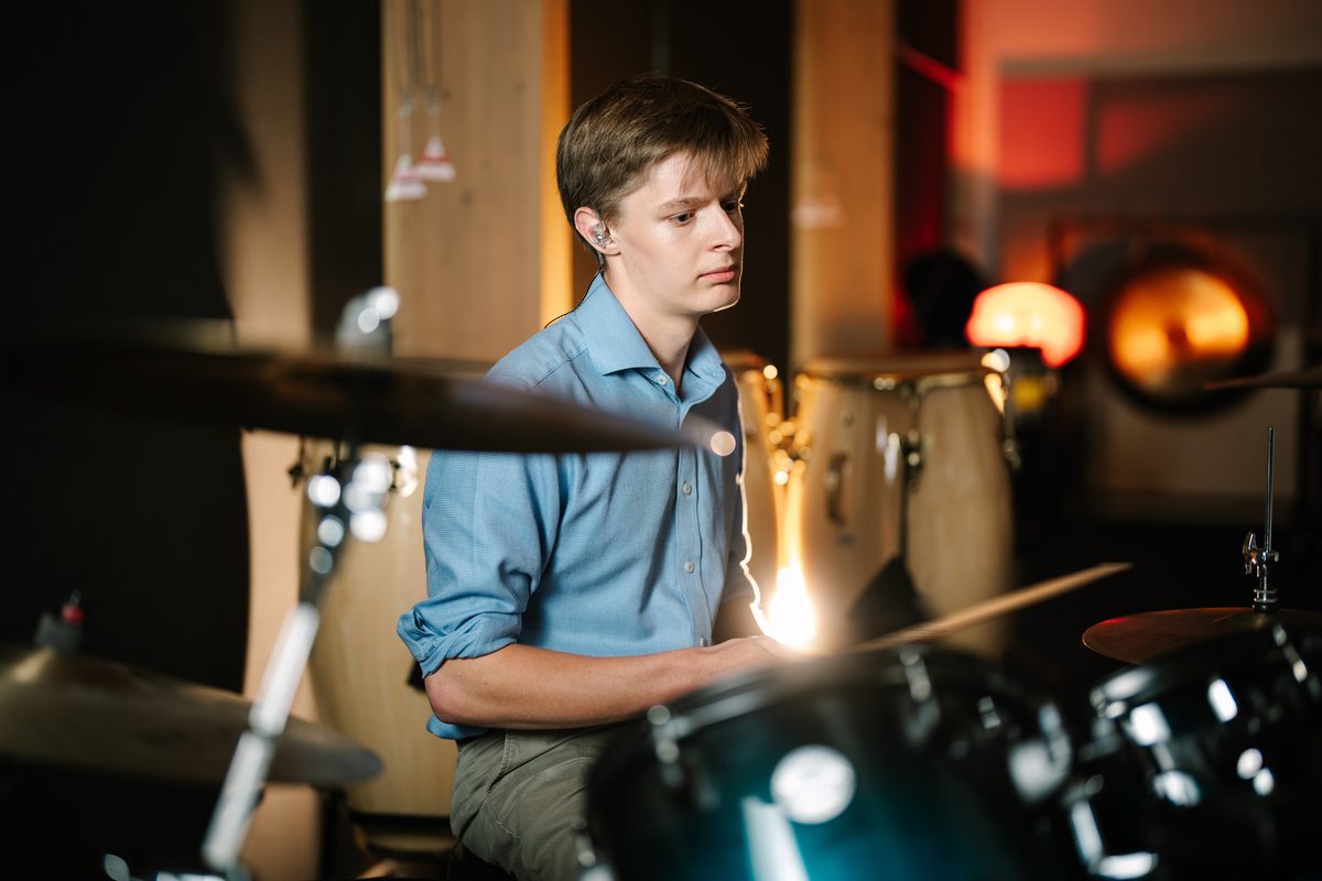 Archie Macfarlane playing drums in the studio
